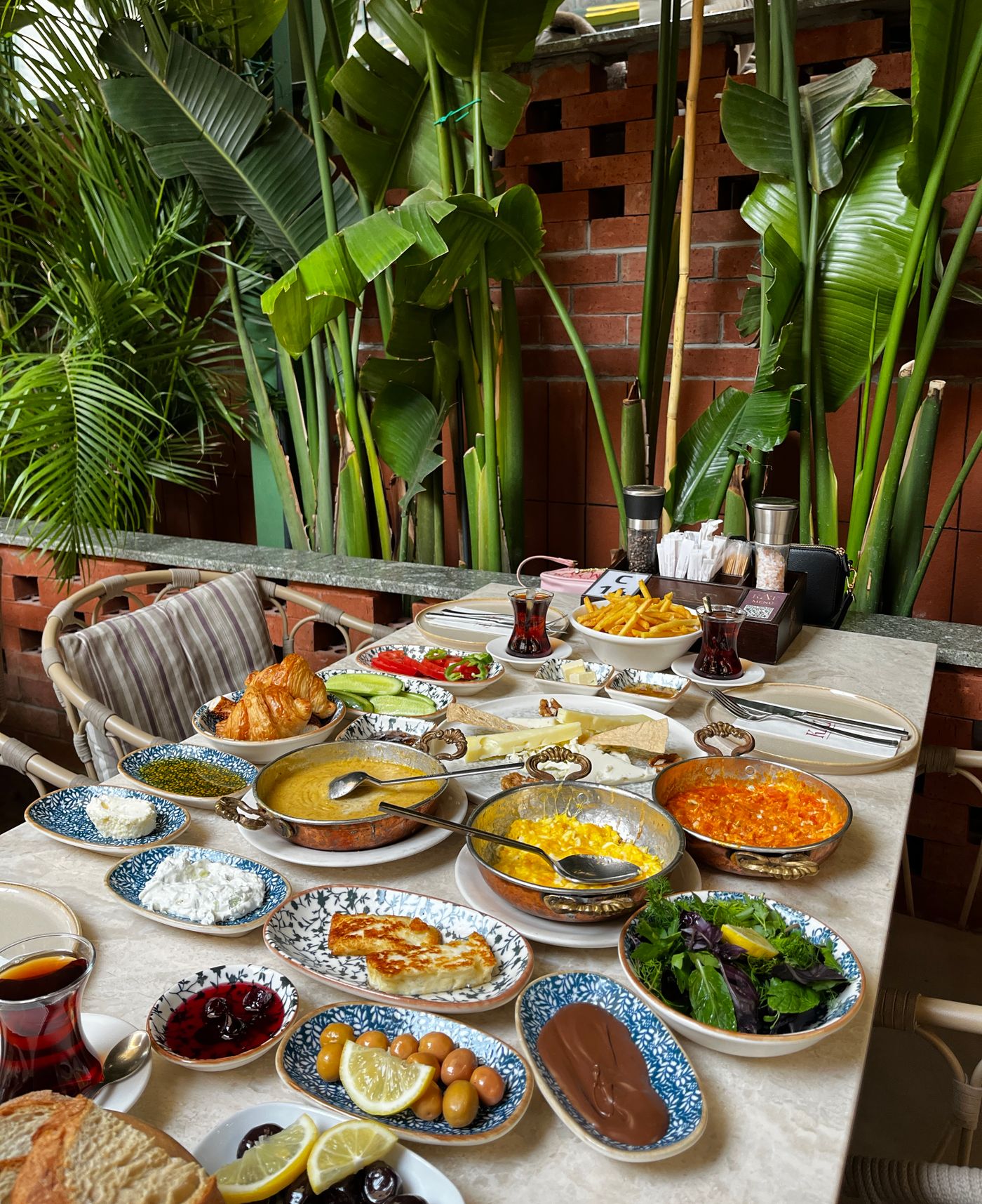 A laden Turkish breakfast table with cheeses, eggs and tea