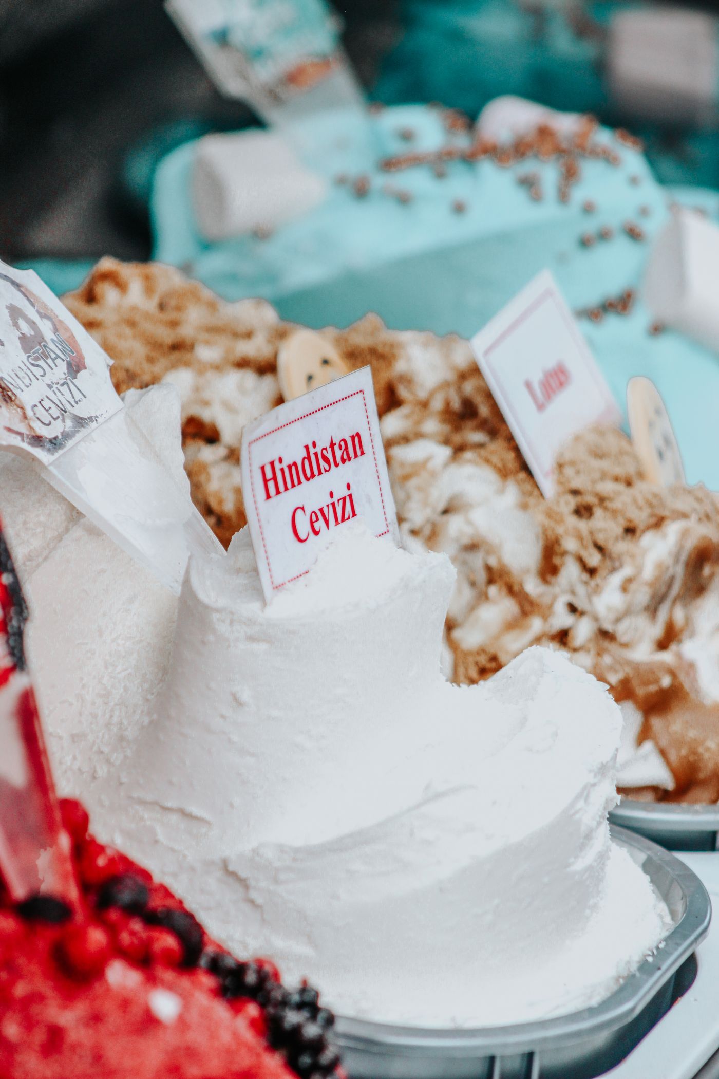 Close-up of stretchy white Turkish dondurma in a chilled case with handwritten Turkish flavour labels including coconut